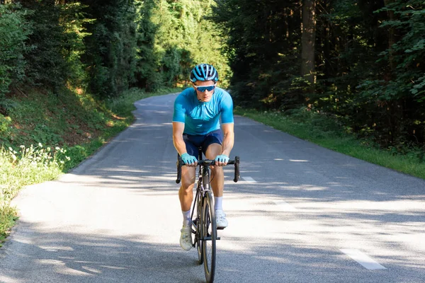 Erkek yol yarışçısı ormanda bir tepeye doğru hızla koşuyor.