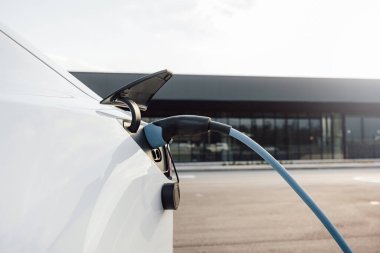 Elektrikli araba şarj aleti, ticaret merkezinin park yerindeki bir araç prizine takılmış.