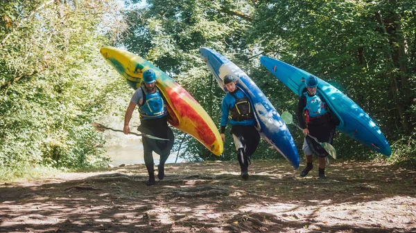 Trois Sportifs Caucasiens Descendent Rivière Transportant Des Kayaks Des Pagaies — Photo