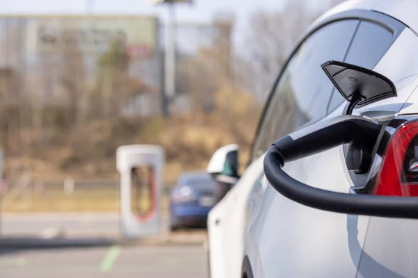 Electric car charger plugged in a vehicle socket at charging station