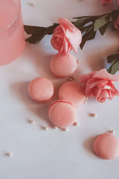 Pink macaroons with bouquet of rose on marble table, pastel colored, Traditional French multicolour macaroon. selective focus. Copy space