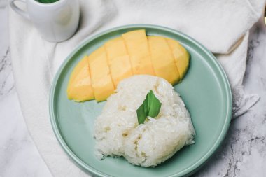 Hindistan cevizi sütüyle (Khao Niew Ma Muang) mango ve yapışkan pirinç. Yaz mevsimi için Tayland tatlısı..