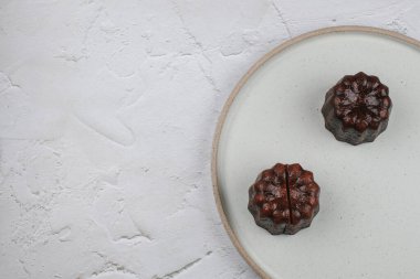 Caneles de Bordeaux - geleneksel Fransız tatlı tatlısı. Rom ve vanilya aromalı krema merkezi ve kalın karamelize kabuklu.