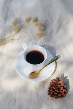 Piknik battaniyesinde beyaz fincanda sıcak kahve. Sabah arkaplanı tatilde dinleniyor. Güneş ışınları. Hayat konsepti. Uzayı kopyala Renkli sonbahar pikniği