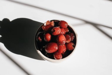 Çin kırmızı tarihi ya da güneş ışığı altında beyaz arka planda sağlıklı bitkisel meyve için Jujube Asya meyvesi. Meyve ve tohumları geleneksel Çin tıbbında kullanılır..