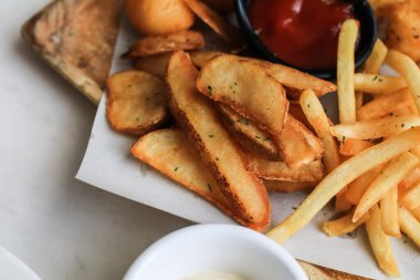 Patates kızartması ya da ahşap masa arkasında ketçaplı patates kızartması. Ev yapımı fırında kızartılmış.