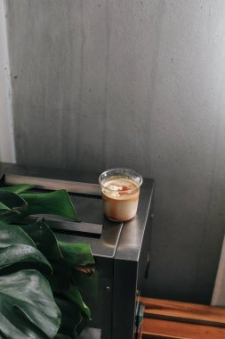 Elle bir bardak kirli latte kahve al. Kahve dükkanı ve restoranda soğuk taze sütle karıştırılmış espresso shot.