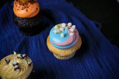 Parti için çırpılmış çikolata ve vanilya kremalı enfes kekler, arka planda doğum günü..