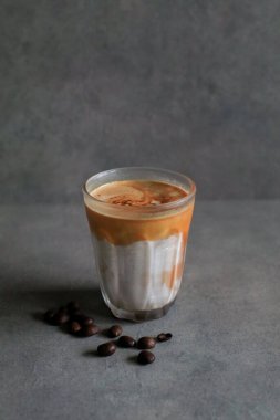 Sabahleyin koyu arka planda soğuk taze sütle karıştırılmış kirli latte kahve. Kahve dükkanı..