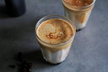 Sabahleyin koyu arka planda soğuk taze sütle karıştırılmış kirli latte kahve. Kahve dükkanı..