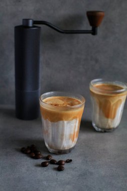 Sabahleyin koyu arka planda soğuk taze sütle karıştırılmış kirli latte kahve. Kahve dükkanı..