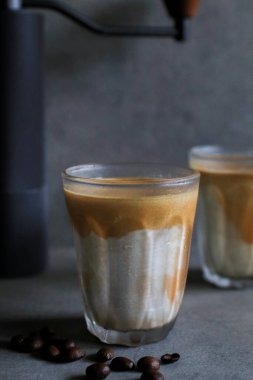 Sabahleyin koyu arka planda soğuk taze sütle karıştırılmış kirli latte kahve. Kahve dükkanı..