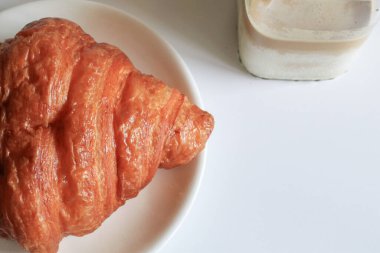 Kahvaltıda sıcak tereyağlı kruvasan ve kahve. Fransız ve Amerikan kruvasanları ve fırınlanmış hamur işleri. Sağlıklı beslenme ve tatlı yemek kavramı.