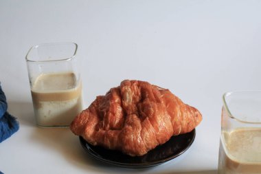 Kahvaltıda sıcak tereyağlı kruvasan ve kahve. Fransız ve Amerikan kruvasanları ve fırınlanmış hamur işleri. Sağlıklı beslenme ve tatlı yemek kavramı.