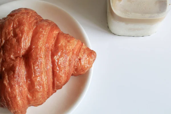 Kahvaltıda sıcak tereyağlı kruvasan ve kahve. Fransız ve Amerikan kruvasanları ve fırınlanmış hamur işleri. Sağlıklı beslenme ve tatlı yemek kavramı.