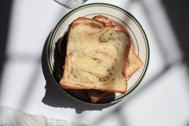 Pencerenin altından beyaz arka planda siyah trüf ve peynirli Brioche ekmeği. Lezzetli ekmekle birlikte fırın içeriği. Hamur işleri.