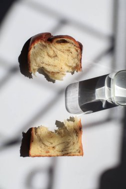 Pencerenin altından beyaz arka planda siyah trüf ve peynirli Brioche ekmeği. Lezzetli ekmekle birlikte fırın içeriği. Hamur işleri.