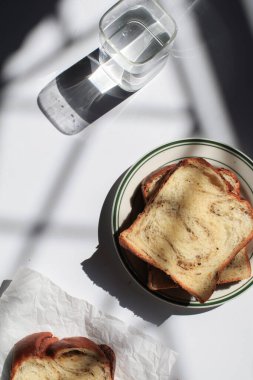 Pencerenin altından beyaz arka planda siyah trüf ve peynirli Brioche ekmeği. Lezzetli ekmekle birlikte fırın içeriği. Hamur işleri.