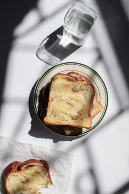 Pencerenin altından beyaz arka planda siyah trüf ve peynirli Brioche ekmeği. Lezzetli ekmekle birlikte fırın içeriği. Hamur işleri.