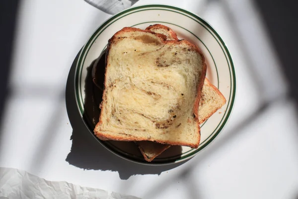 Pencerenin altından beyaz arka planda siyah trüf ve peynirli Brioche ekmeği. Lezzetli ekmekle birlikte fırın içeriği. Hamur işleri.