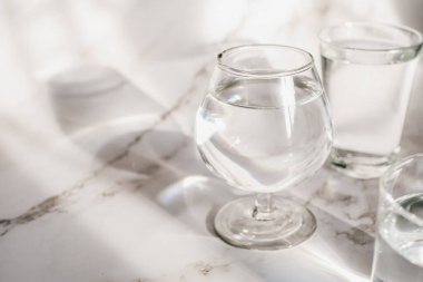 Suyun camından geçen güneş ışığı beyaz zemin üzerindeki ışığın kırılması ile ışık ve gölgenin güzel bir desen oluşturmasını sağlar..