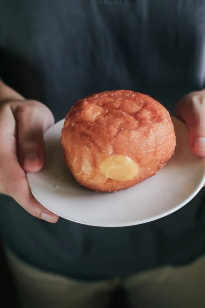Hand pick doughnuts with Creamy Lemon Filling Dusted on white plate. copy space for your text. Snack food and dessert.