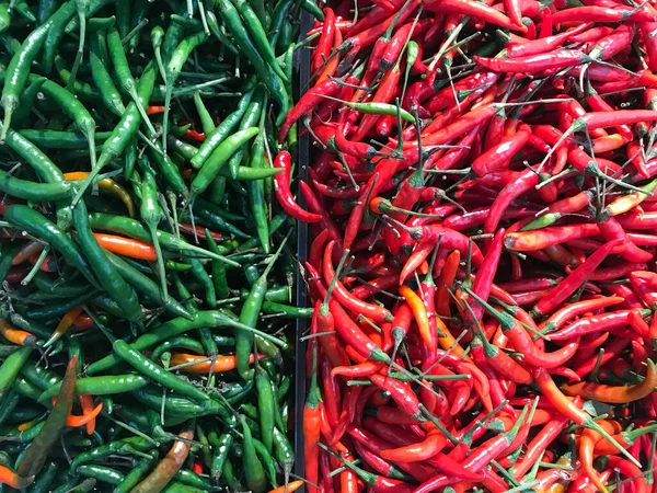 Fresh red chili and green chili variety in a a vegetable market. Food background. Harvest.