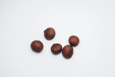 Chestnuts on white background. Pile of fresh chestnuts ready to roast. Top view, copy space. Flat lay. Space for text