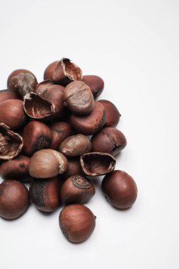 Chestnuts on white background. Pile of fresh chestnuts ready to roast. Top view, copy space. Flat lay. Space for text