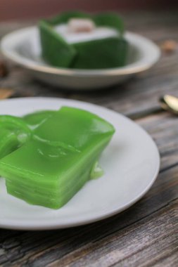 Steamed Layer sweet cake or Khanom Chan Thai traditional dessert (Green Pandan flavour) in white plate. Famous desserts in Thailand.