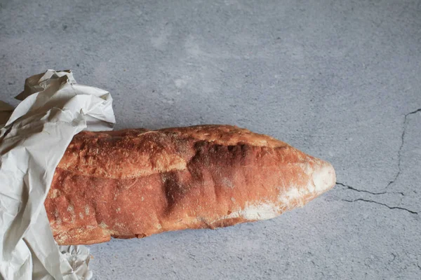 Baguette bread in package on gray background. Bread bun, French baguette. Tasty delicious crusty bread in bakery