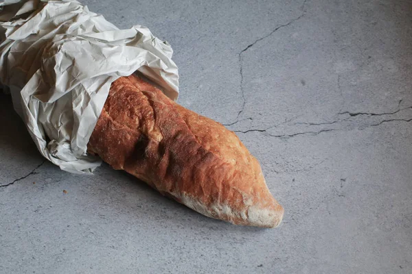 Baguette bread in package on gray background. Bread bun, French baguette. Tasty delicious crusty bread in bakery