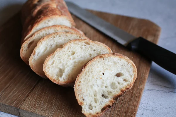 French Baguette bread on wooden cutting board background. Bread bun, Tasty delicious crusty bread in bakery