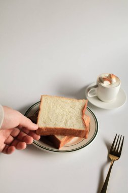 Beyaz pastırma arkaplanının üzerinde lokum olan dilimlenmiş ekmek ve kahve. Sabah kahvaltısı, kahve molası. Lezzetli içecek ve tatlı fırın. Kış ve Sonbahar kavramı