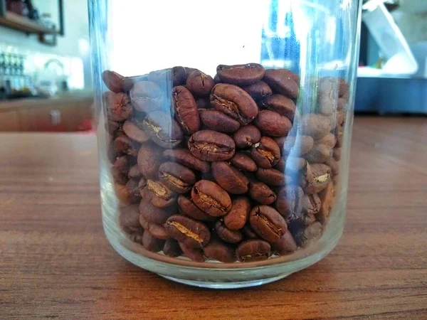 sehpanın üzerinde bardakta kahve çekirdeği.