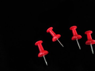 Koyu siyah arkaplanda çok renkli pin başparmak raptiyeleri izole