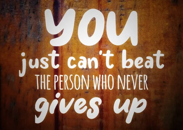 Quote on wood background for motivation and inspiration  business or saying you can't beat the person who never gives up 