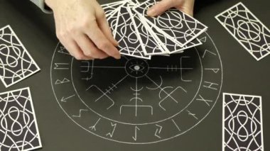 Yetişkin bir kadın tarot kartını açar ve koyar. Falcı kadının elleri açık ve masasında tarot sunağıyla talih kuşu kartını gösteriyor. Tahmin konsepti.