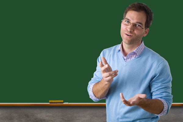 Teacher in front of a blank green chalk board