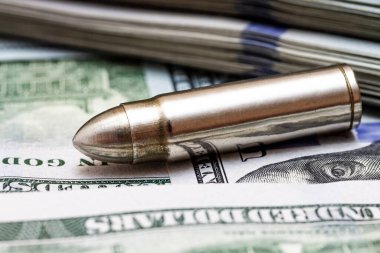 Amerikan dolarlarının arka planında yatan kurşuna yakın plan. Banknotların üzerindeki silahtan çıkan cephane.. 