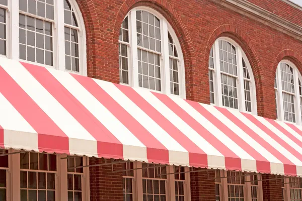 Brick Building With Striped Awning — Stock Photo, Image