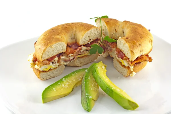 Bagel de bacon e ovo com abacate fatiado — Fotografia de Stock