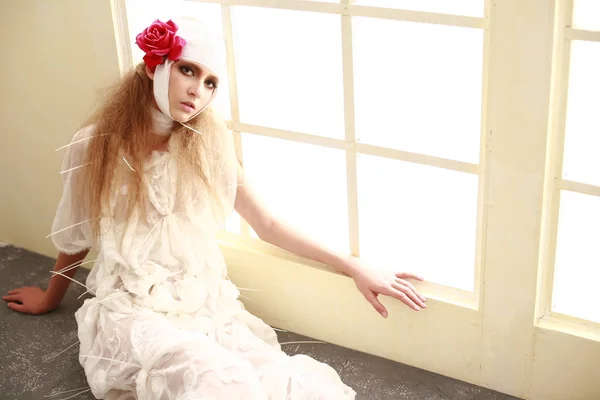 bandajlı bir kafa, hasta kırmızı bornoz duran genç, kırılgan kız süper çiçek