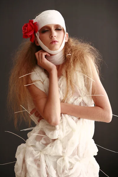 genç, kırılgan kız hasta kırmızı çiçek bandajlı bir kafayla Bornozlu ayakta