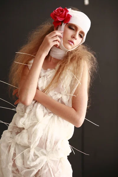 genç, kırılgan kız hasta kırmızı çiçek bandajlı bir kafayla Bornozlu ayakta