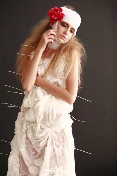 genç, kırılgan kız hasta kırmızı çiçek bandajlı bir kafayla Bornozlu ayakta