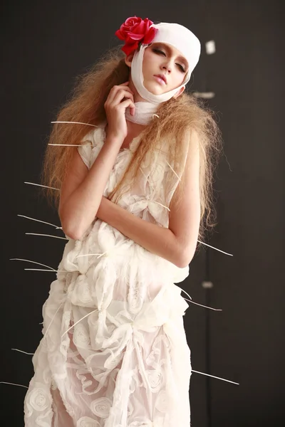 genç, kırılgan kız hasta kırmızı çiçek bandajlı bir kafayla Bornozlu ayakta