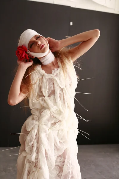 genç, kırılgan kız hasta kırmızı çiçek bandajlı bir kafayla Bornozlu ayakta