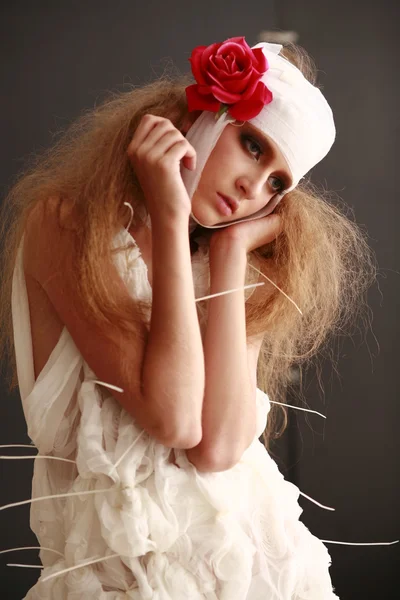 genç, kırılgan kız hasta kırmızı çiçek bandajlı bir kafayla Bornozlu ayakta