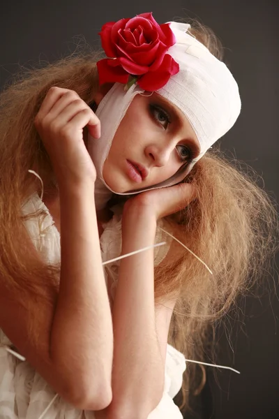 genç, kırılgan kız hasta kırmızı çiçek bandajlı bir kafayla Bornozlu ayakta